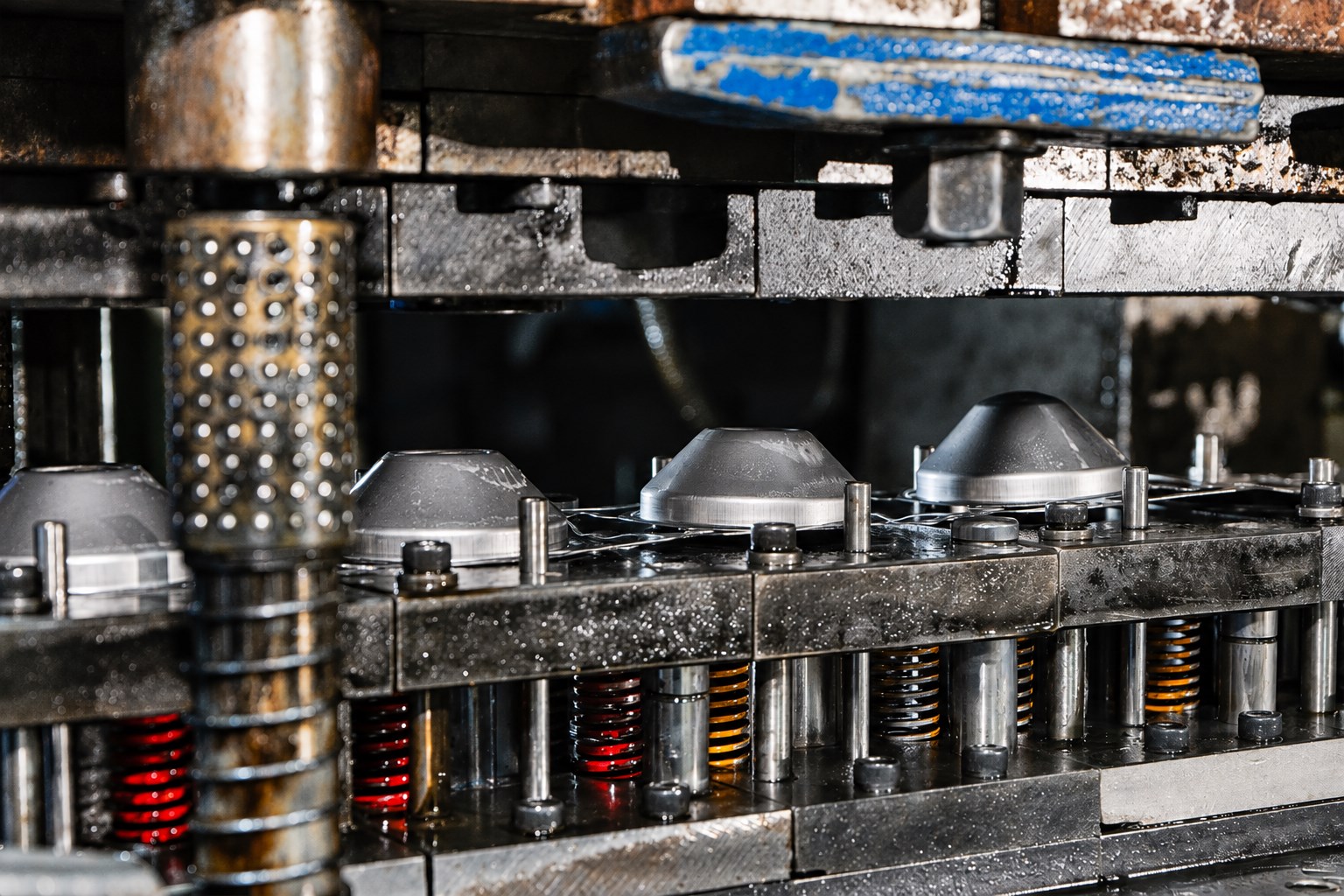 Close-up of automatic stamping tooling and formed metal components