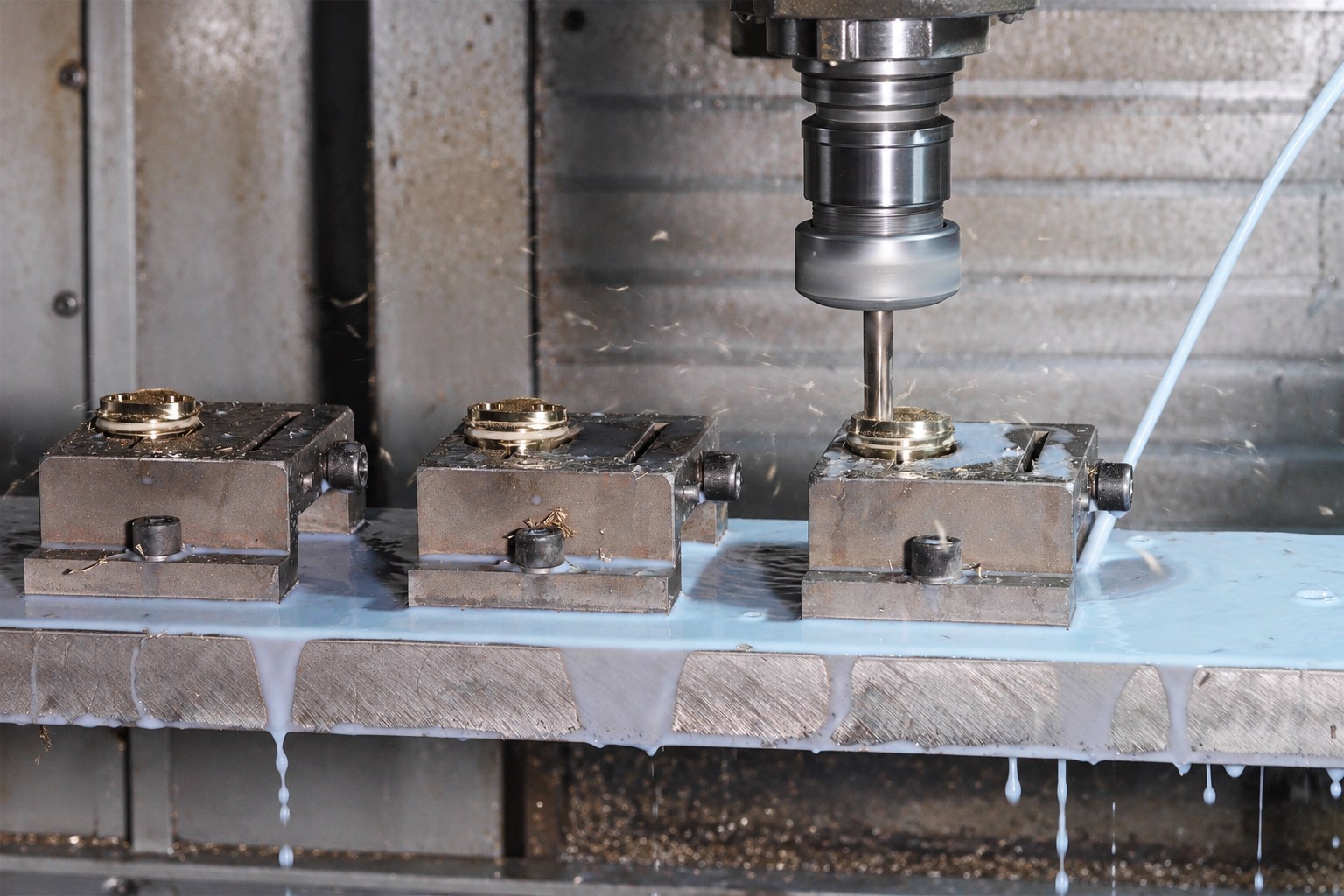 Close-up of drilling metal components held in a machining fixture